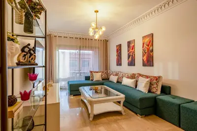 a living room with a green couch and a table at Urban Pearl terrace and pool in Marrakech