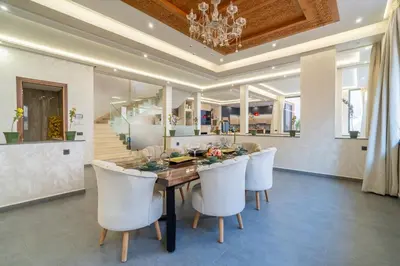 a dining room with a table and white chairs at Villa Traverta Marrakech, 5 Suites, Heated Pool, Workation & Authentic Hammam in Marrakech