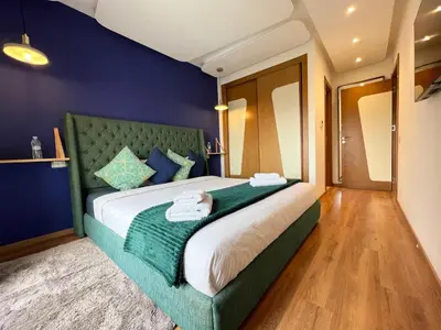 a bedroom with a large bed with a green headboard at Top Floor Apartment with terrace and pool in Marrakech