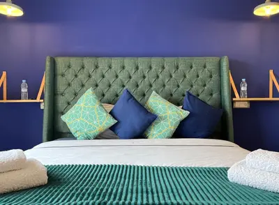 a bedroom with a green bed with blue pillows at Top Floor Apartment with terrace and pool in Marrakech