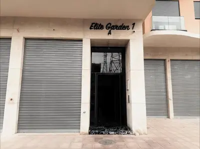 a building with a garage door and a sign on it at Cosy Studio Cinema PS5 and home cinema 10 min Downtown in Marrakech