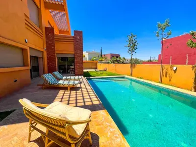 a swimming pool with two lounge chairs next to a building at Sublime Villa avec Piscine et Jardin à Marrakech in El Rhechat