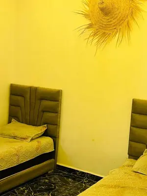 two beds in a room with a yellow wall at Spacious and comfortable villa in Marrakech