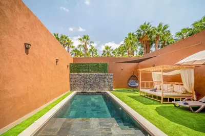 an external view of a house with a swimming pool and grass at Villa Cõrdõba piscine chauffée et sans vis-à-vis in Marrakech