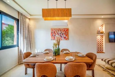 a dining room with a wooden table and chairs at Villa Cõrdõba piscine chauffée et sans vis-à-vis in Marrakech