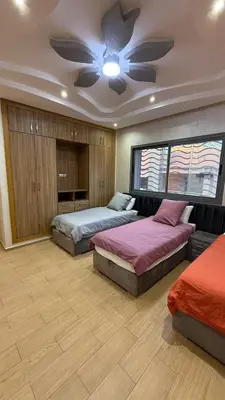 a bedroom with two beds and a ceiling fan at Villa Targa Marrakech in Marrakech
