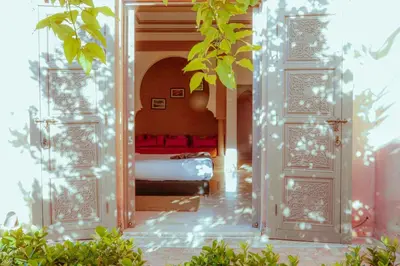 a bedroom with a bed in a room with trees at Palais Soufi 8 chambres in Marrakech