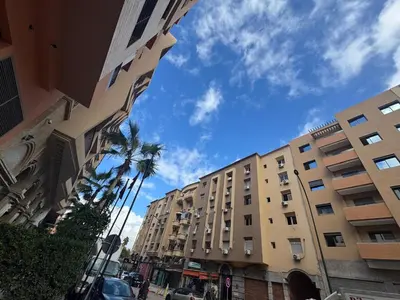 a city street with tall buildings and palm trees at Marrakech guliz location vacances in Marrakech