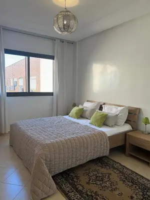 a bedroom with a large bed with a large window at Residence La Perle de Atlas Appartement in Marrakech