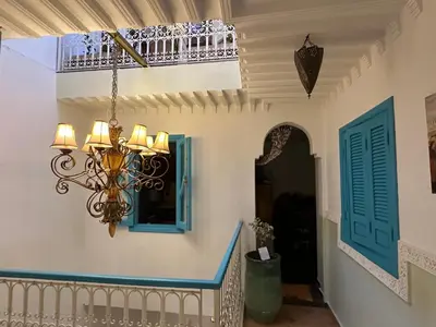a room with a chandelier and a staircase with a window at Cosy private riad 3 rooms in Marrakech