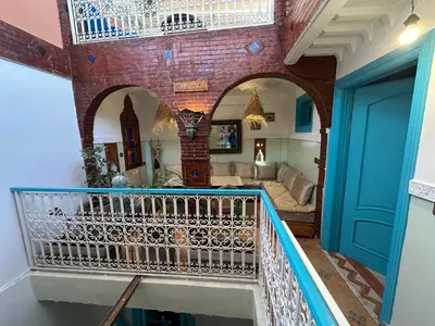 a house with a balcony and a living room at Cosy private riad 3 rooms in Marrakech