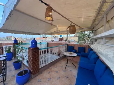 a balcony with blue couches and a table at Cosy private riad 3 rooms in Marrakech