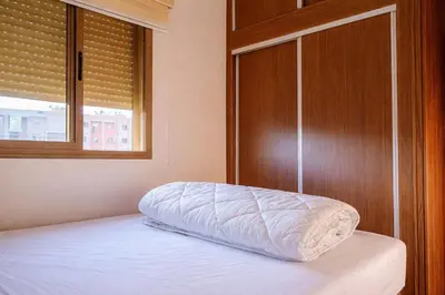 a bedroom with a bed with a wooden door and a window at 2 bedrooms abouab gueliz in Marrakech