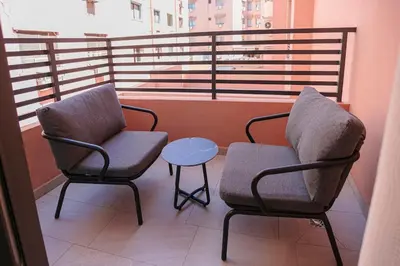 two chairs and a table on a balcony at Palmier d'or - Marrakech Centre in Marrakech