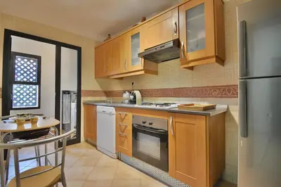 a kitchen with wooden cabinets and a stainless steel refrigerator at Marrakxi in Marrakech