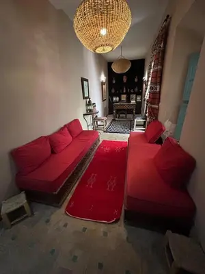 a living room with two red couches and a chandelier at Luxury riad breakfast included in Marrakech