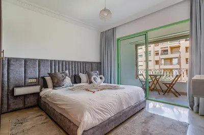 a bedroom with a large bed and a balcony at Cosy Palace elevator and pool in Marrakech