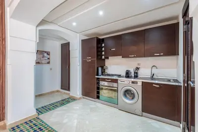 a kitchen with a washing machine and a sink at Cosy Palace elevator and pool in Marrakech