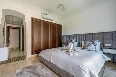 a bedroom with a large bed with a wooden headboard at Cosy Palace elevator and pool in Marrakech