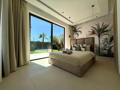 a bedroom with a large bed and a large window at Villa Terracotta Marrakech in Segraga