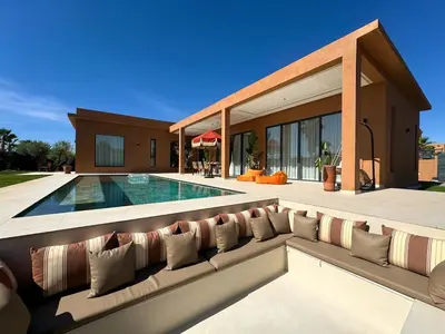 a living room with a couch and a swimming pool at Villa Terracotta Marrakech in Segraga