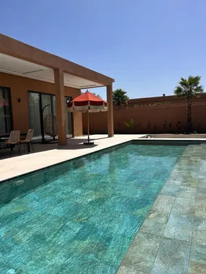 a swimming pool with a red umbrella and an umbrella at Villa Terracotta Marrakech in Segraga
