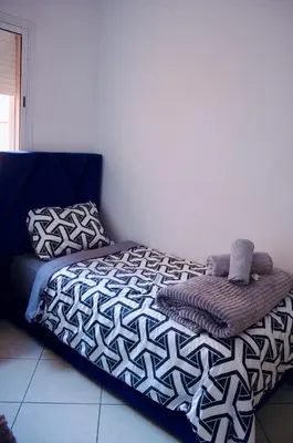 a bedroom with a bed with a blanket and pillows at Khamo Apartment, 15 min Walking to Airport, 15 min by Taxi to Medina in Marrakech