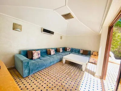 a living room with a blue couch and a table at Villa Youri in Marrakech