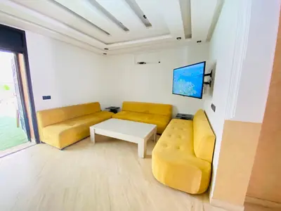 a living room with two yellow couches and a table at Villa Youri in Marrakech