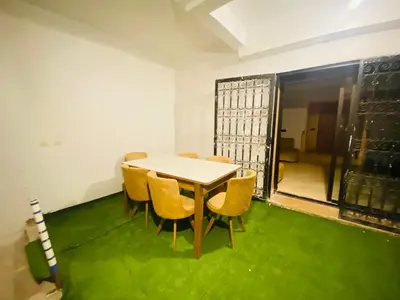 a table and chairs in a room with green carpet at Villa Youri in Marrakech