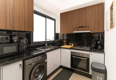 a kitchen with a stove and a sink and a dishwasher at Cosy Appartement de Luxe F3 Menara Garden Hivernage Marrakech avec piscine in Marrakech
