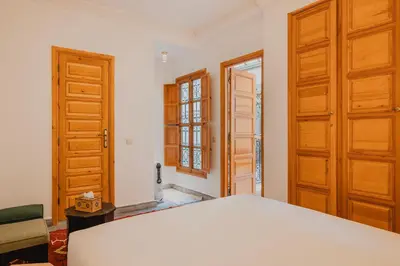 a room with two wooden doors and a bed at Riad Al Mechouar in Marrakech