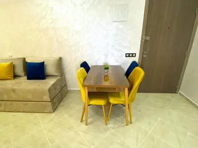 a table and chairs in a living room with a couch at Appartement à Marrakech confortable et équipe in Marrakech
