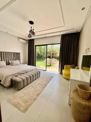 a bedroom with a large bed and a large window at Villa privée in Taazout