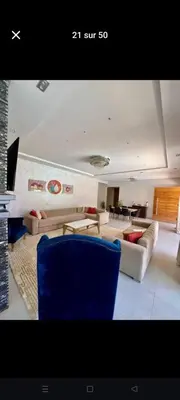 a living room with couches and a blue chair at Villa privée in Taazout