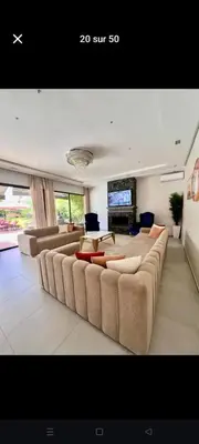 a living room with couches and a flat screen tv at Villa privée in Taazout