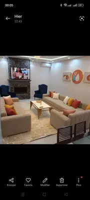 a living room with two couches and a tv at Villa privée in Taazout