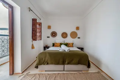 a bedroom with a bed in a white room at Riad Zahra Private Pool and Breakfast10min Jemaa in Marrakech