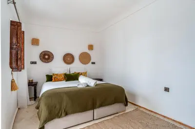 a bedroom with a bed in a white room at Riad Zahra Private Pool and Breakfast10min Jemaa in Marrakech