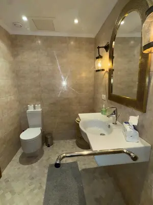 a bathroom with a sink and a toilet and a mirror at Bel Appartement 2 Chambres spacieux avec Piscine in Marrakech