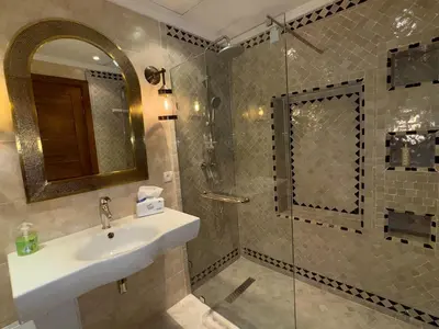 a bathroom with a sink and a glass shower at Bel Appartement 2 Chambres spacieux avec Piscine in Marrakech