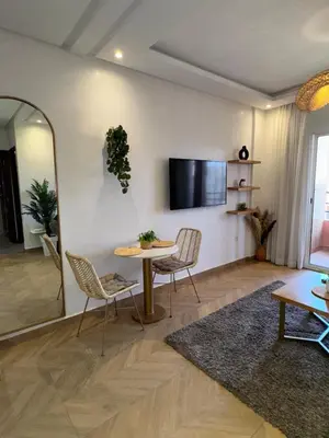 a living room with a table and chairs and a tv at Elegant apartment in Guéliz in Marrakech