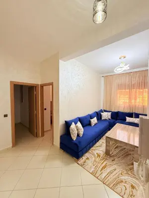 a living room with a blue couch and a table at 2 Aprt Moderne Neuf Adapté Au Famille in Marrakech