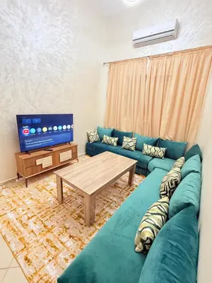 a living room with a blue couch and a tv at 2 Aprt Moderne Neuf Adapté Au Famille in Marrakech