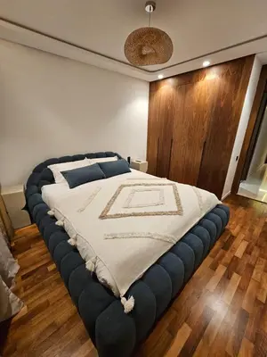 a large bed in a room with a wooden wall at Luxurious New Designer Apartment in Marrakech in Marrakech
