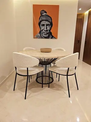 a dining room table with two chairs and a painting at Luxurious New Designer Apartment in Marrakech in Marrakech
