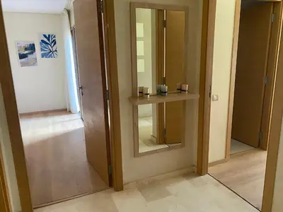 a hallway with a door with a shelf and a mirror at appartement à prestigia golf marrakech- SAPHIR in Marrakech