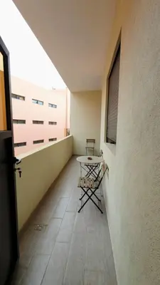 a small balcony with a table on the side of a building at Charming Marrakech Appartement in Marrakech