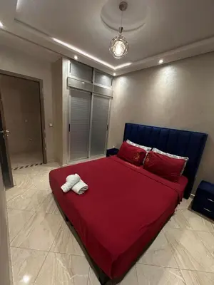 a bedroom with a large red bed with red pillows at Modern Marrakech Apartment in Marrakech