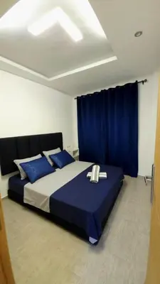 a bedroom with a large bed with blue pillows at Charming Marrakech Duplex in Marrakech